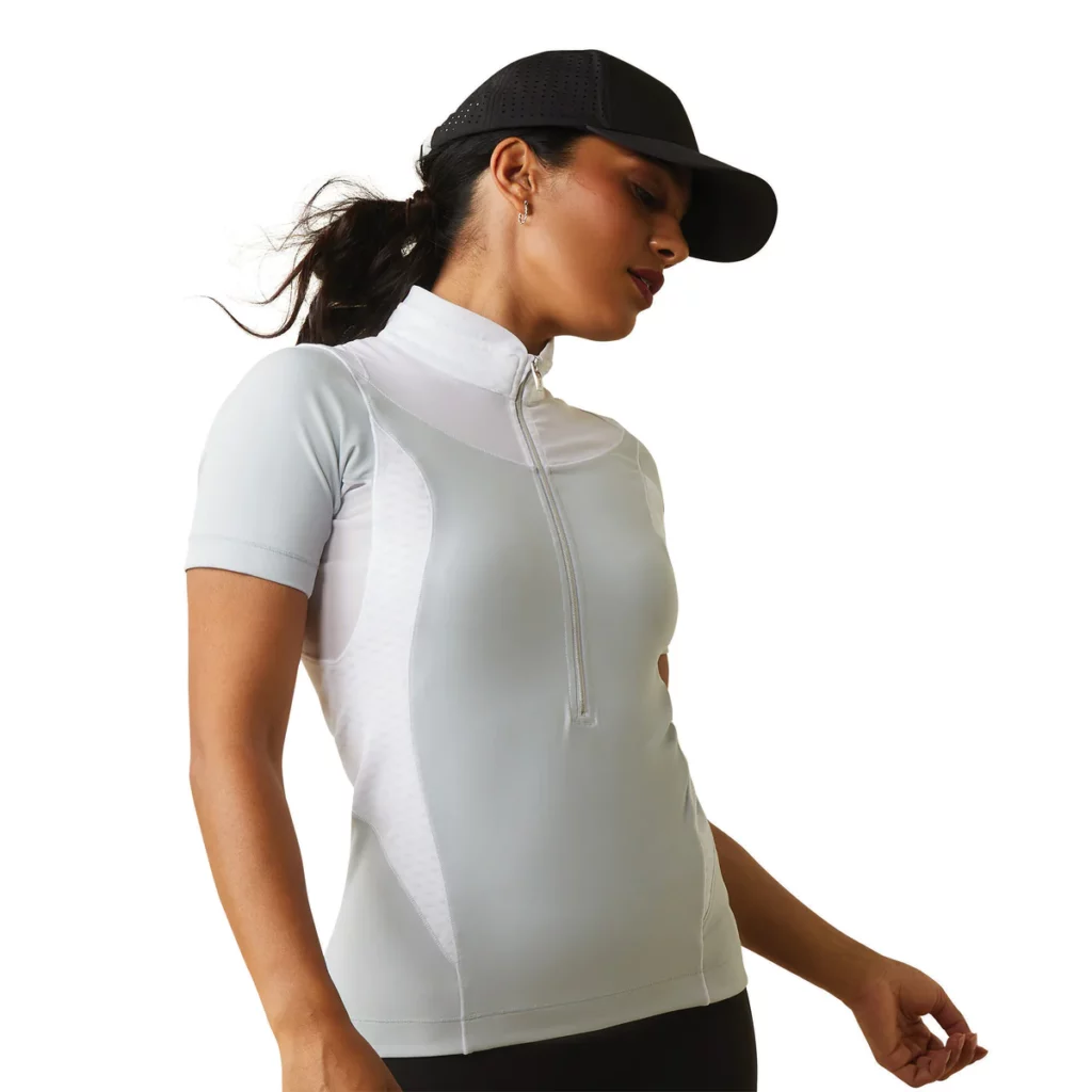Woman wearing a white Ariat short sleeve, half zip baselayer 