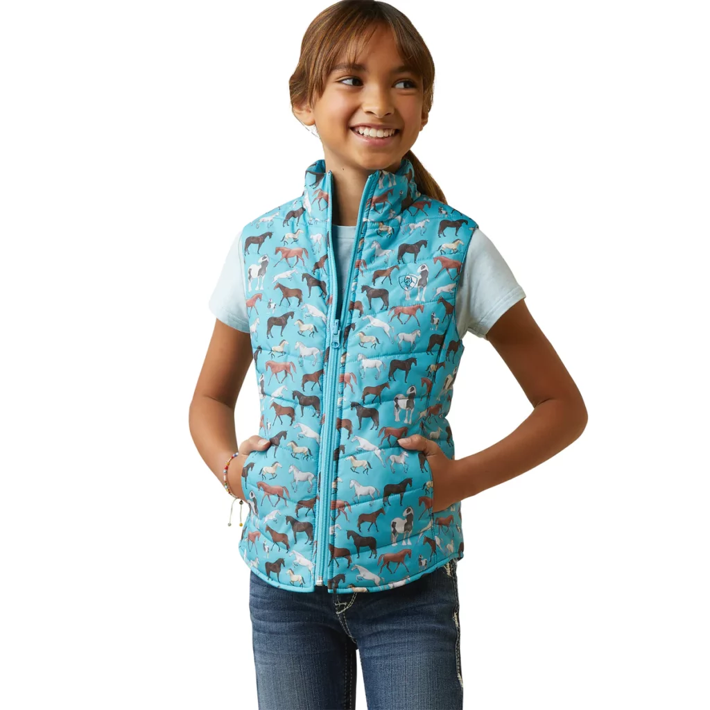 Ariat girls blue puffy vest patterned with black, brown, grey, and white horses