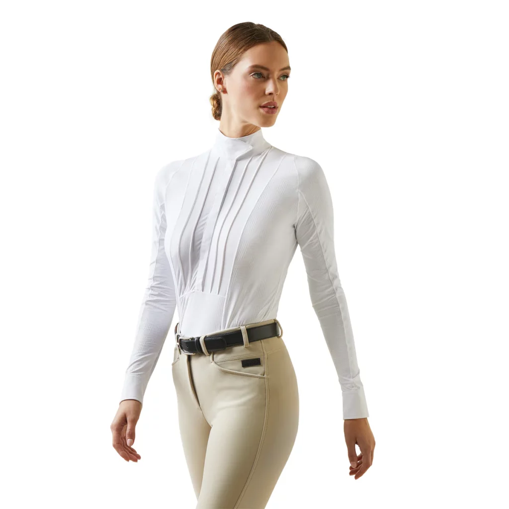 Woman wearing a white long-sleeve show shirt with tan breeches